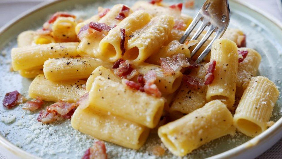 A stock image shows a plate of pasta carbonara