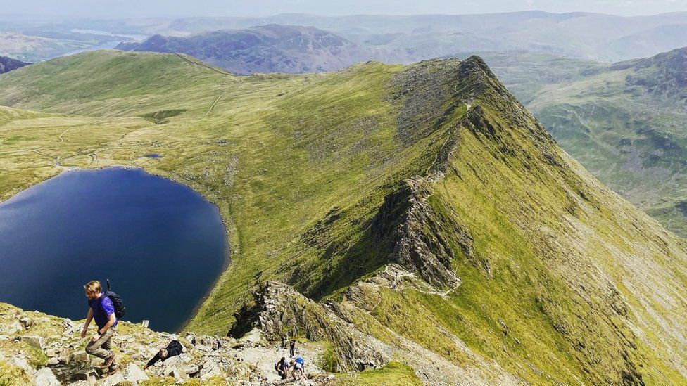 Walkers climb Striding Edge towards the top of Helvellyn