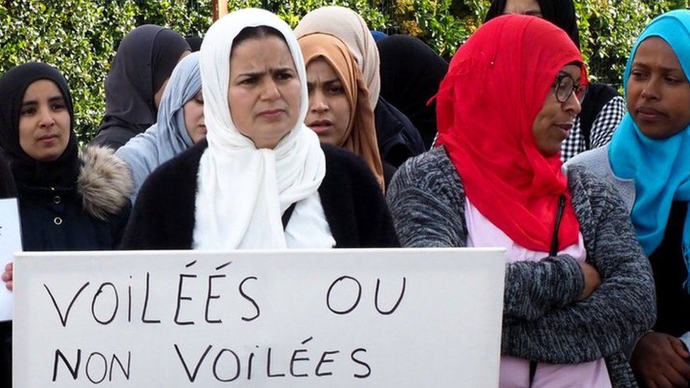 Demonstrators outside a school in south-western France hold a placard reading: "Veiled or not veiled, we want equality" (28 May 2019)
