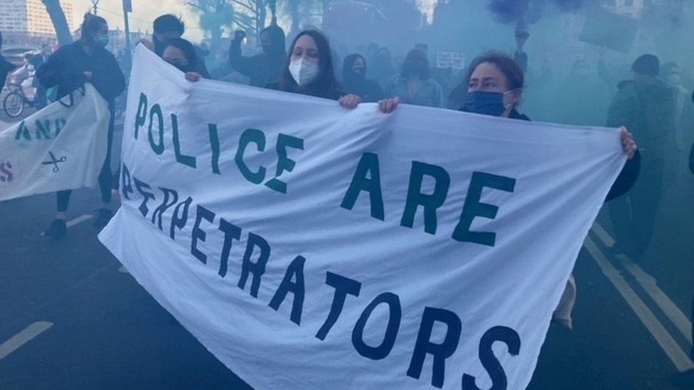 Protester holds a banner outside Scotland Yard