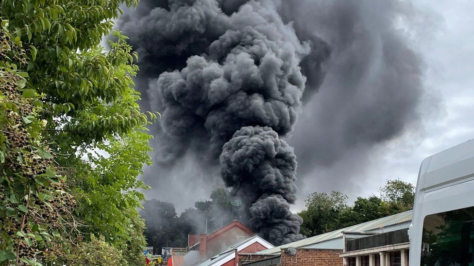 Plume of smoke above car workshop fire