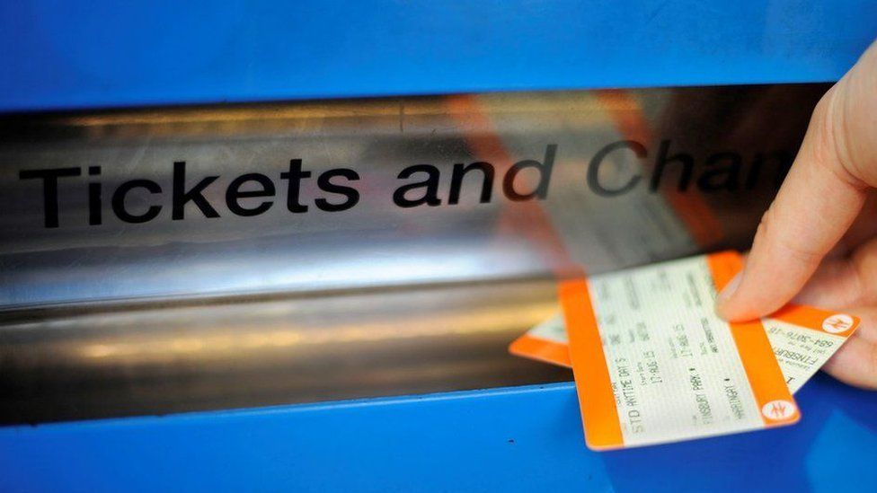 A hand taking train tickets from a ticket machine