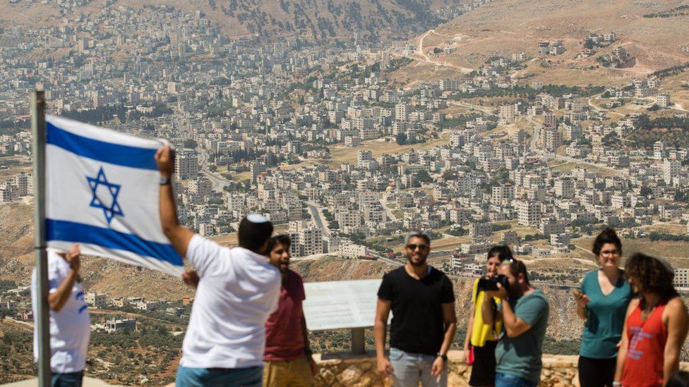 Israeli students hold Israeli flag near West Bank settlement of Elon Moreh (file photo)
