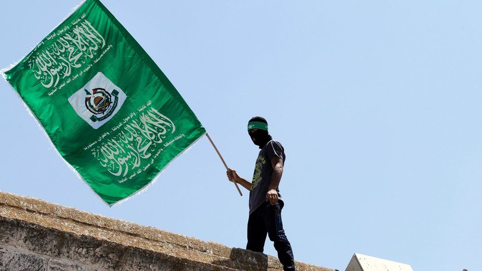 This file photo taken on July 03, 2015 shows a Palestinian man waving the green flag of the Islamist movement Hamas during a demonstration outside the Dome of the Rock at the Al-Aqsa Mosque compound in Jerusalem.