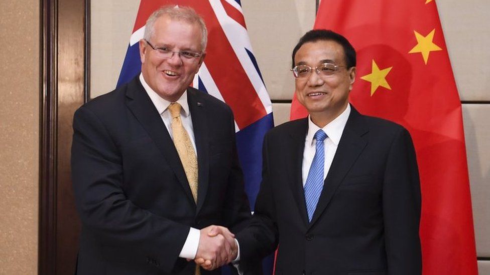 Scott Morrison and Li Keqiang shake hands in front of the flags of both nations at the ASEAN summit in November 2019