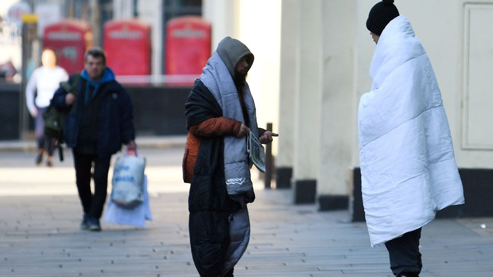 Homeless people stand on a pavement during rush hour in Central London, as the spread of the coronavirus disease (COVID-19) continues, in London, Britain