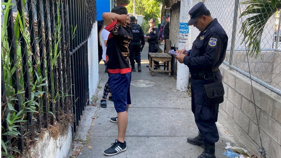 A police officers stops a man in the street