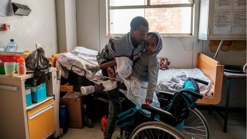 Арсема Берха, 9 лет, перемещена в свою кровать родственником в больнице Айдер, столице Мекеле, 25 февраля 2021 года, после того, как она была ранена во время боев между Народным фронтом освобождения Тыграя (НФОТ), павшим после атаки Эфиопии Премьер-министр в конце прошлого года направил войска и боевые самолеты, чтобы вытеснить НФОТ