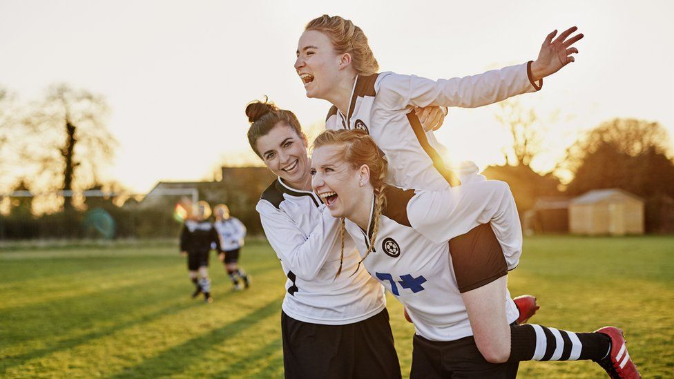 Three young women playing football