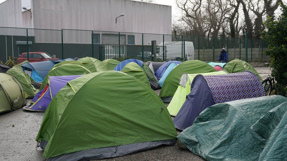 Migrants camp on an industrial estate near the Calais Ferry terminal on January 31, 2020 in Calais, France