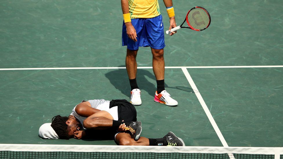 Tennis player Dustin Brown in agony after twisting his ankle during a match