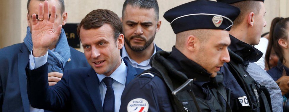 Emmanuel Macron waves to supporters on 24 April