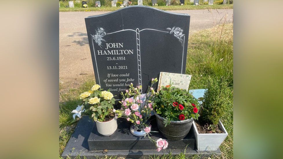 Grave for John Hamilton surrounded by flowers 