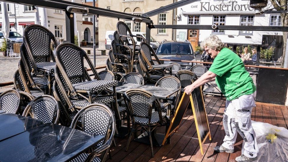 Chairs and tables are prepared for outdoor dining at a restaurant in Aalborg, Denmark