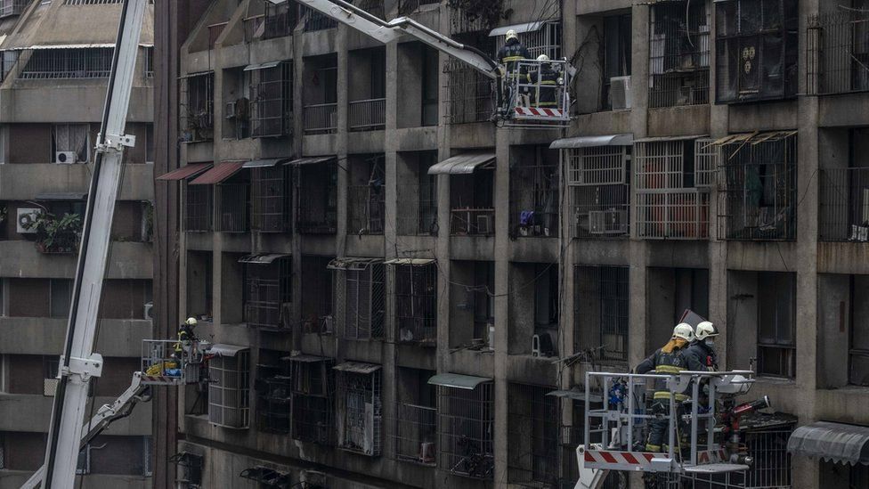 Firefighters search for victims from a residential building in the wake of a fire on 14 October 2021, in Kaohsiung, Taiwan