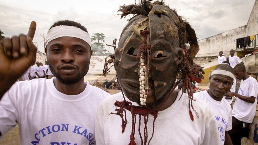 Two young fighters in Kananga town - one wears a traditional mask used in witchcraft ceremonies.