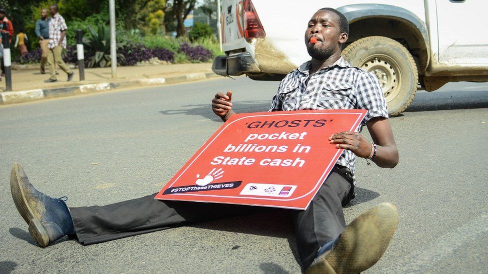 Man sitting on the floor with a placard (archive shot from 2018)