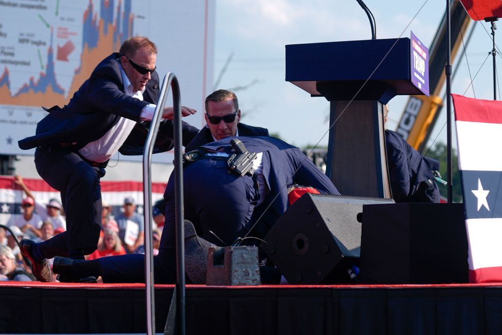 Republican presidential candidate former President Donald Trump is helped off the stage at a campaign event in Butler, Pa., on Saturday, July 13, 2024. 