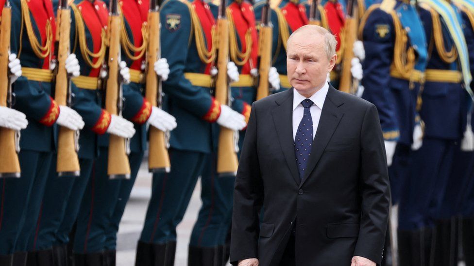 Russian President Vladimir Putin walks in front of a row soldiers