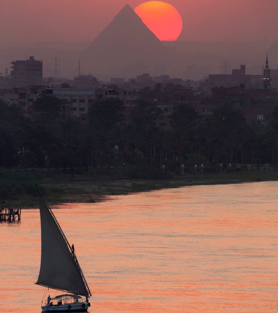 The sun sets over the historical site of the Giza Pyramids and the Nile River, near Cairo, Egypt, Friday, Aug. 19, 2016.