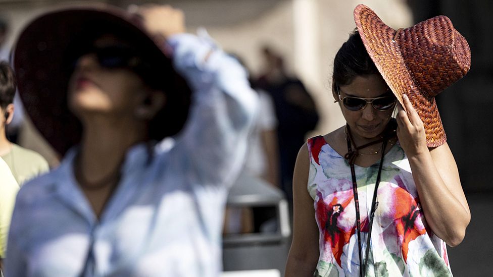 Women wearing hats for sun protection amid a heatwave and high temperatures, in Rome, Italy, 18 July 2023