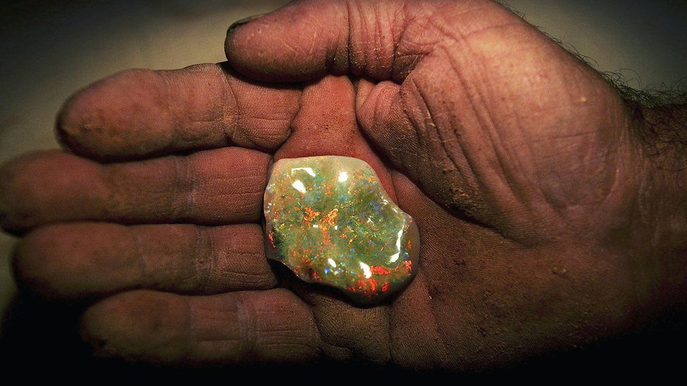 An Australian miner holds an opal