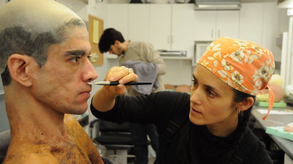 A make-up artist applies make-up to Javier's face
