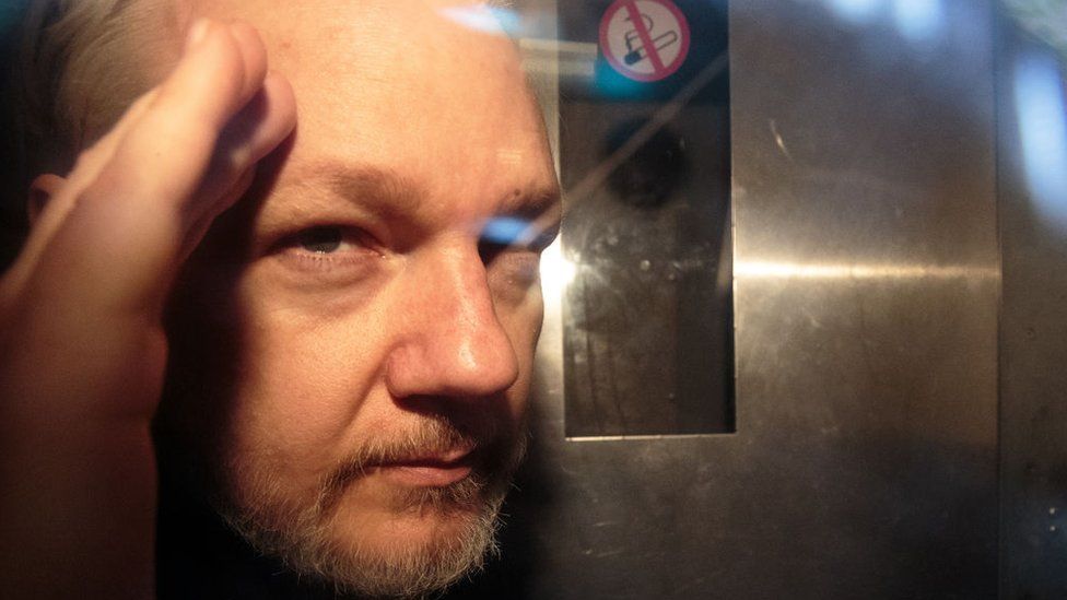 Julian Assange pictured inside a security van