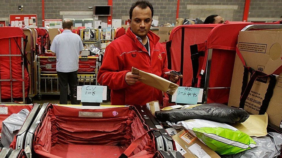 Royal Mail worker sorts parcels and letters