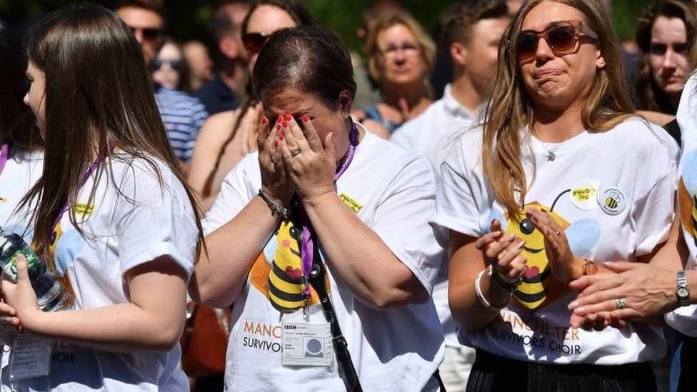 A woman cries outside Manchester Cathedral
