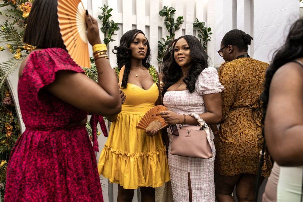 Women wearing smart clothes and dresses wait to enter the celebrity zone during the Lagos International Polo Tournament Finals.
