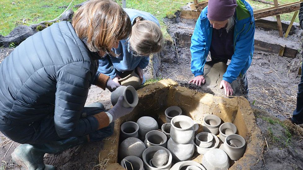 Pots being stacked in the recreated Anglo-Saxon kiln before firing