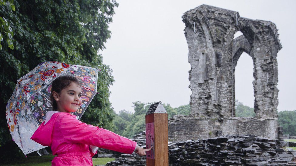 Carys, seven, tries out one of the new audio posts at Neath Abbey