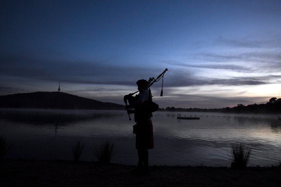 A bagpipe player plays at the Winter Solstice Nude Charity Swim in Canberra