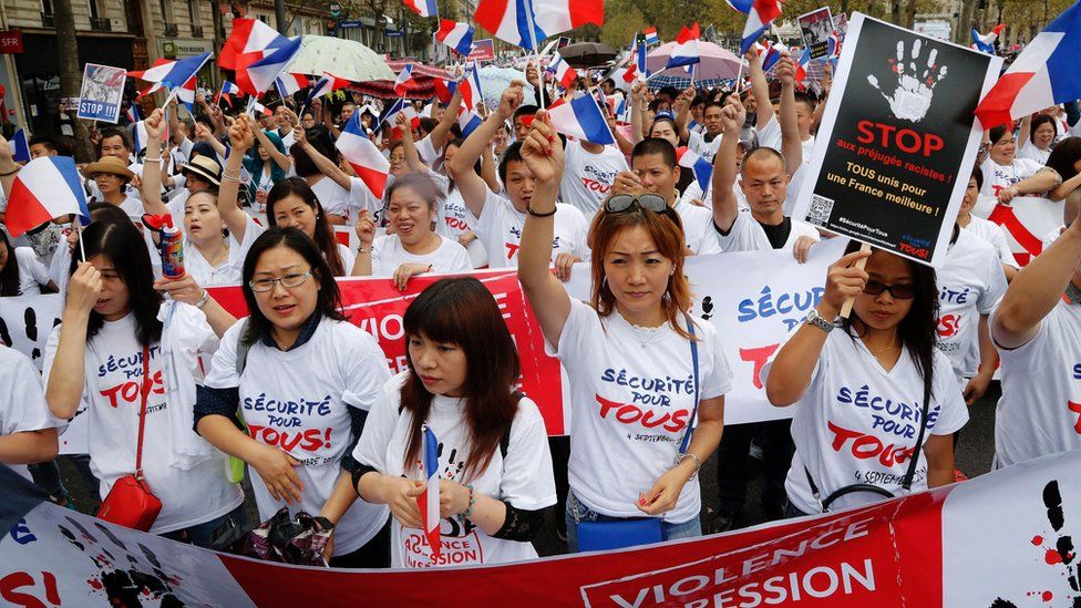 Members of the Chinese community in Paris wave French flags and hold placards during a demonstration on September 4, 2016 in Paris, following the death of Zhang Chaolin and also calling for greater security measures.