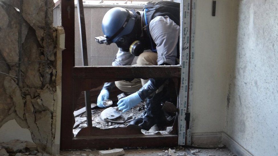 A UN expert collects samples at a site where rockets filled with Sarin hit a suburb of Damascus, Syria (29 August 2013)