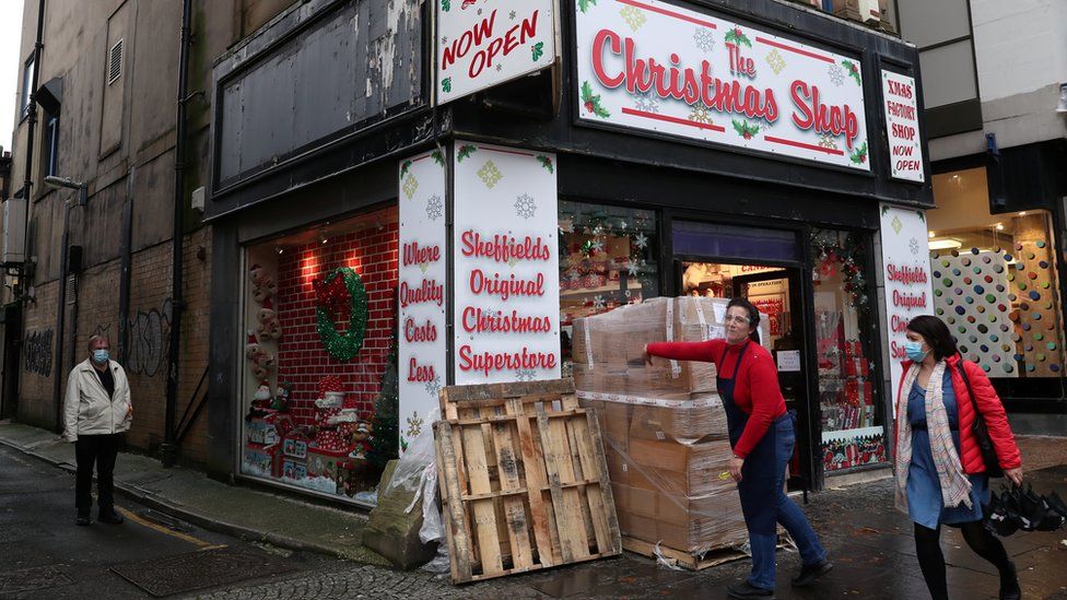 People walk near the Christmas shop during stricter restrictions due to the coronavirus disease (COVID-19) outbreak in Sheffield