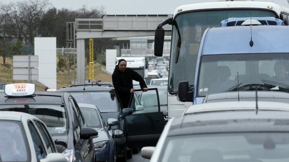 A man watches the traffic on the highway leading to the Orly airport (18 March 2017)