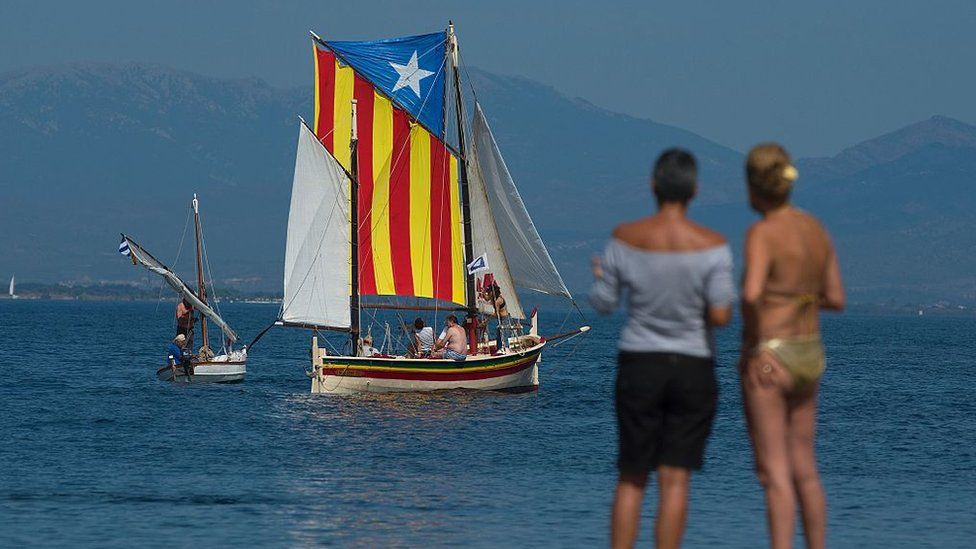 A sail boat carrying an Estelada, the Catalan independence flag, sails off a beach of L'Escala, near Girona on 10 September 2016, on the eve of the National Day of Catalonia, or Diada