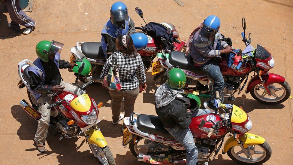 A woman in Rwanda surrounded by motorbike riders
