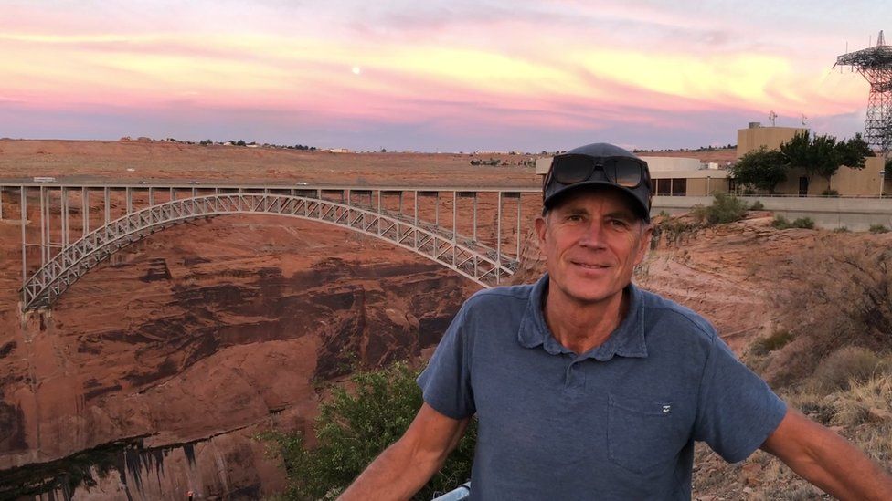 Jim Lochhead poses in front of a Colorado River dam