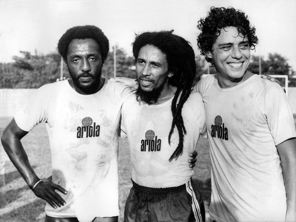 Bob Marley on a football field in Rio de Janeiro, Brazil, in 1980 with football player Paolo Cesar Caju and singer-songwriter Chico Buarque