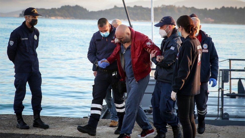 Ein Passagier der unter italienischer Flagge fahrenden Euroferry Olympia steigt im Hafen von Korfu von einem Schiff der griechischen Küstenwache aus
