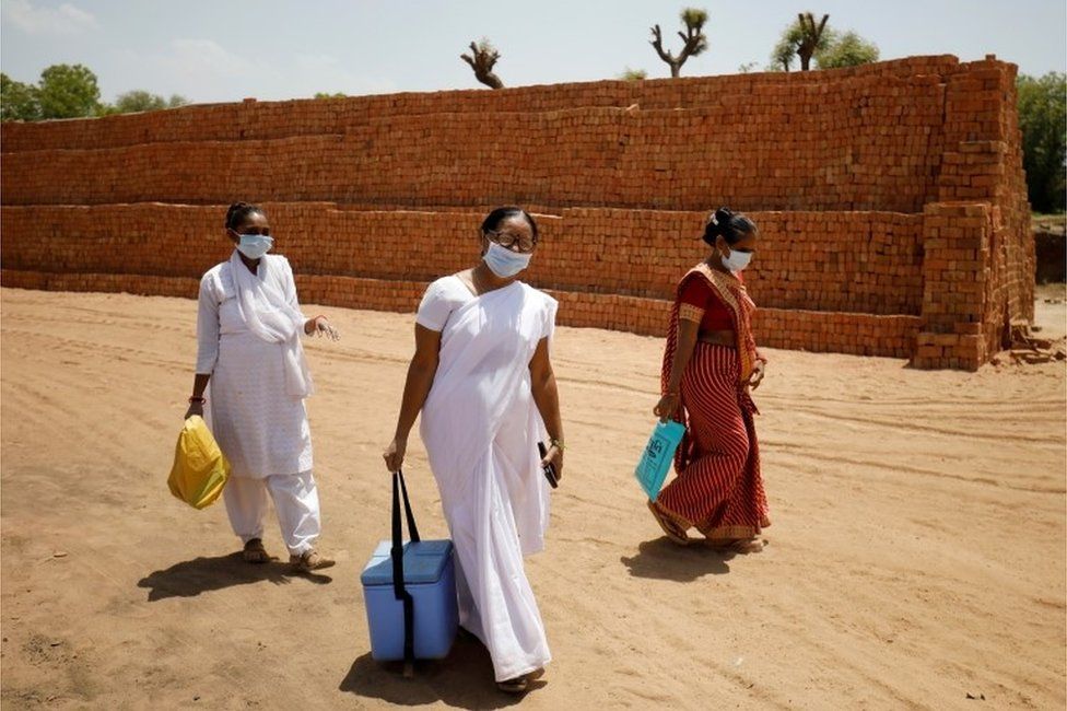 Медицинские работники прибывают с дозами COVISHIELD, вакцины против коронавируса (COVID-19), производимой Институтом сыворотки Индии, для введения рабочим кирпичной печи в деревне Кавита на окраине Ахмедабада, Индия, 8 апреля 2021 г.