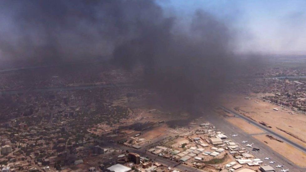 Черный дым поднимается над международным аэропортом Хартума в четверг