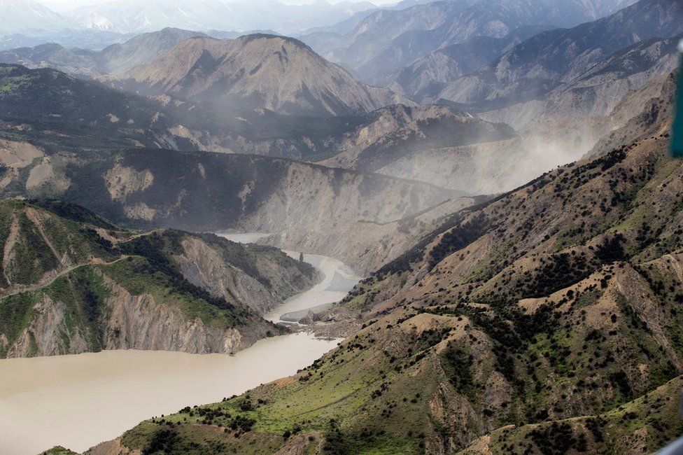 Dust created by a strong aftershock hangs above the Clarence River which was blocked following an earthquake north of Kaikoura, New Zealand, Monday, 14 November 2016.