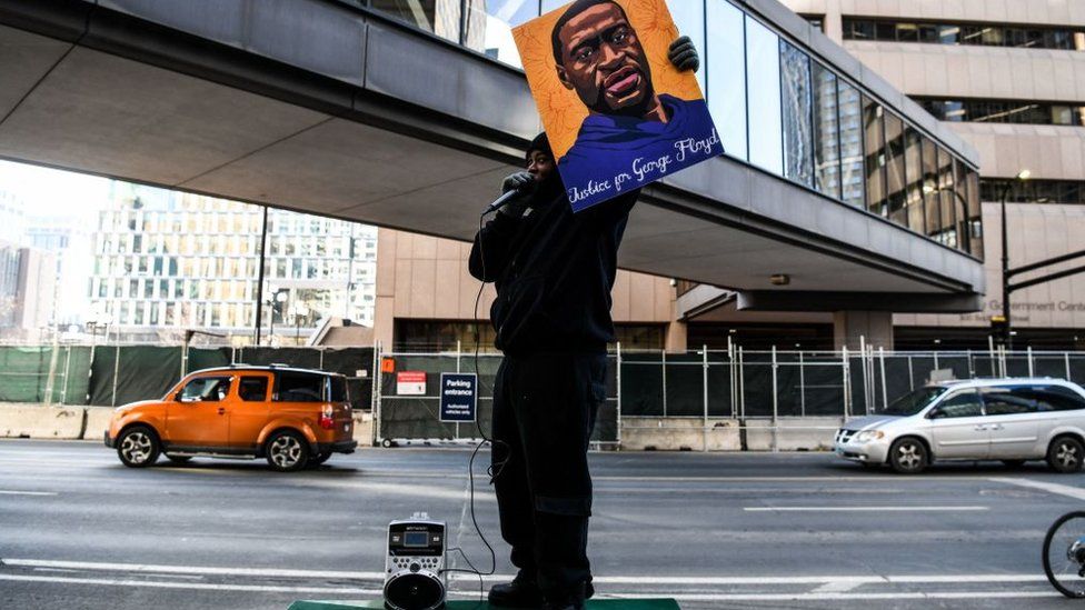 A demonstrator holds a portrait of George Floyd outside the Hennepin County Government Center on March 9, 2021 in Minneapolis, Minnesota.