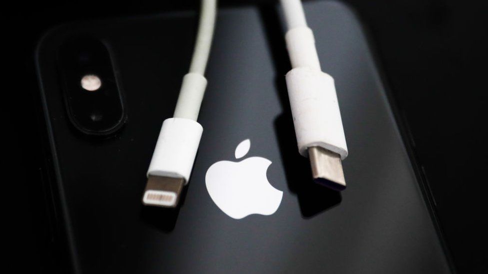 USB-C to lightning iPhone charging cable draped over iPhone