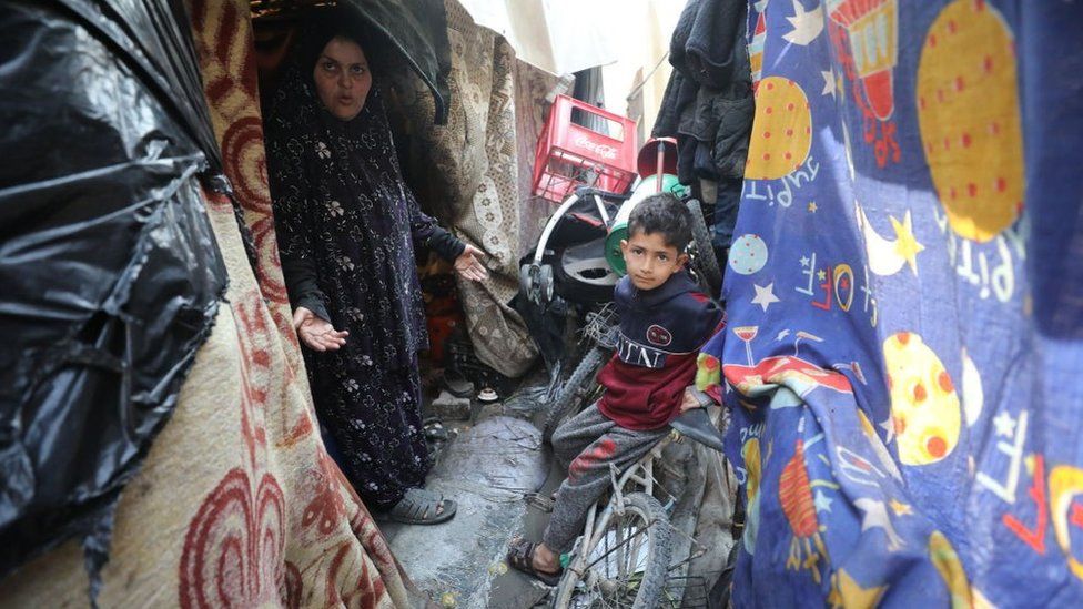 A woman and a child are seen among makeshift tents at Jabalia refugee camp in northern Gaza on 26 February