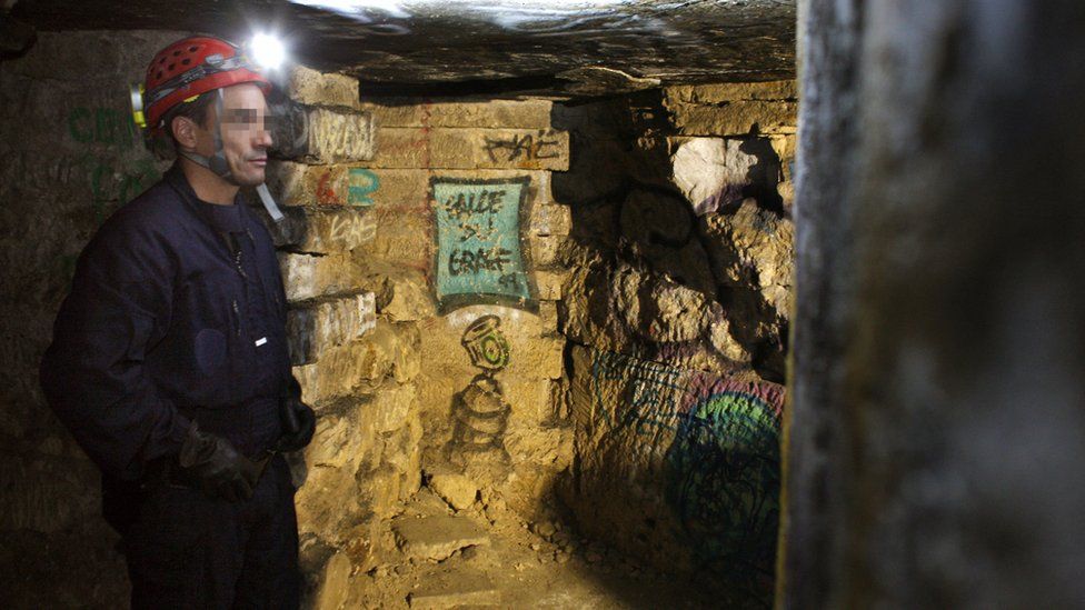 A member of French special police squad 'Brigade d'intervention de la compagnie sportive' patrols in the Paris catacombs on 20 August, 2009.